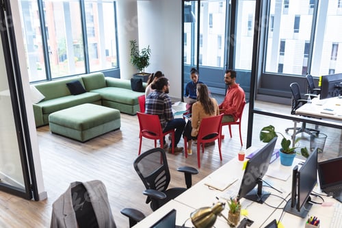 Preview: Diverse group of creative colleagues talking at casual meeting