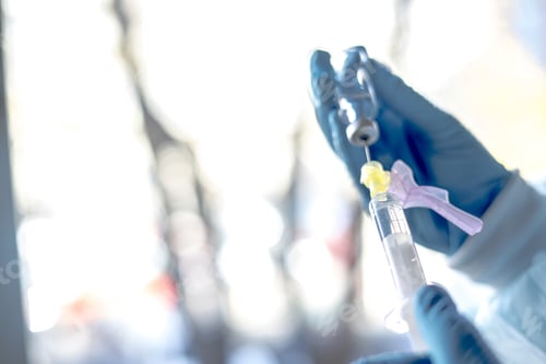 Preview: Medical worker holding the Covid-19 vaccine with a syringe