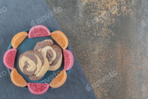 Preview: Two cookies in the middle of marmelades circle on a plate on wooden background
