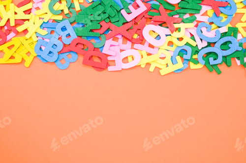 Preview: Top view closeup of the letters of the English alphabet isolated on an orange background