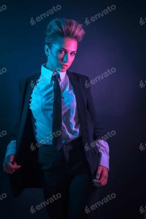 Preview: A sexy young blonde hair female in a black suit posing in studio