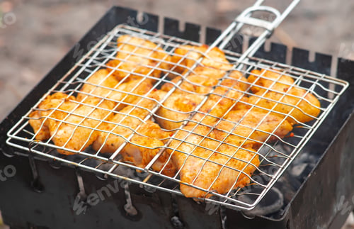 Vista previa: Grilled chicken wings with spices on the grill, cooked on fire, barbecue