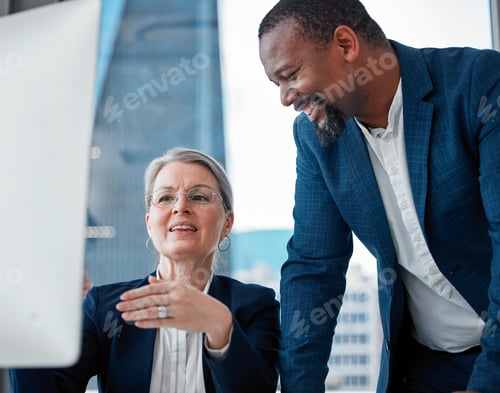 Preview: Shot of two businesspeople having a discussion in the office while using a computer
