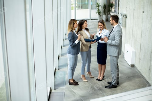 Preview: Young startup team have a discussion by stairs in the office corridor