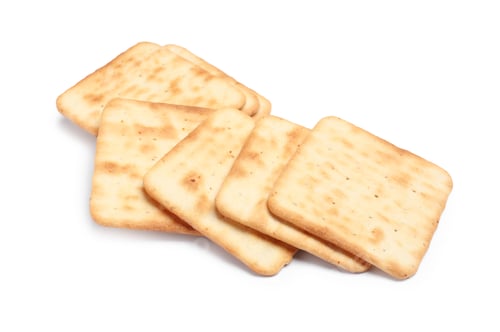 Preview: Tasty crispy square crackers isolated on white