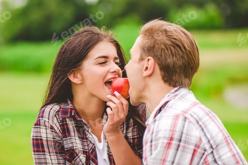 Preview: The man and woman bit an apple