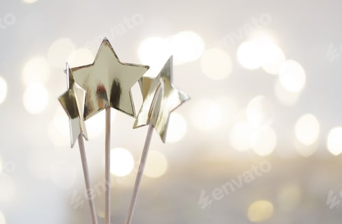 Preview: Three gold colored stars against the bokeh glitter background.