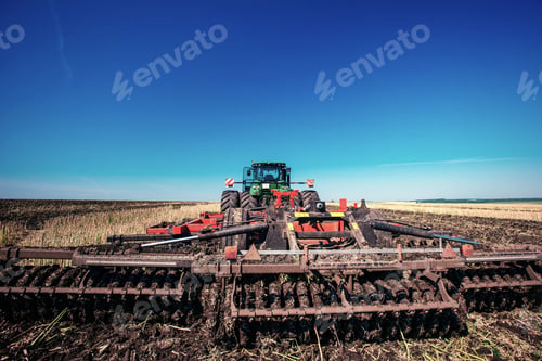 Preview: Tractor plowing farm field in preparation for spring planting