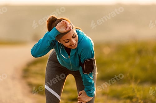 Preview: Exhausted sportswoman taking a break from running in nature.