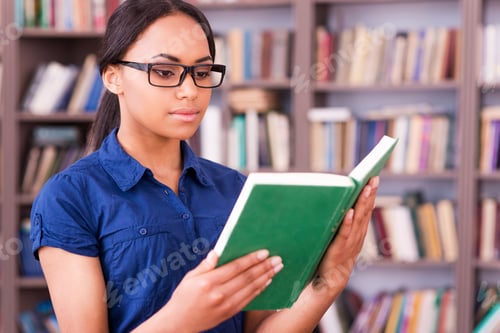 Preview: Concentrated on reading. Confident African female student reading a book while standing in library