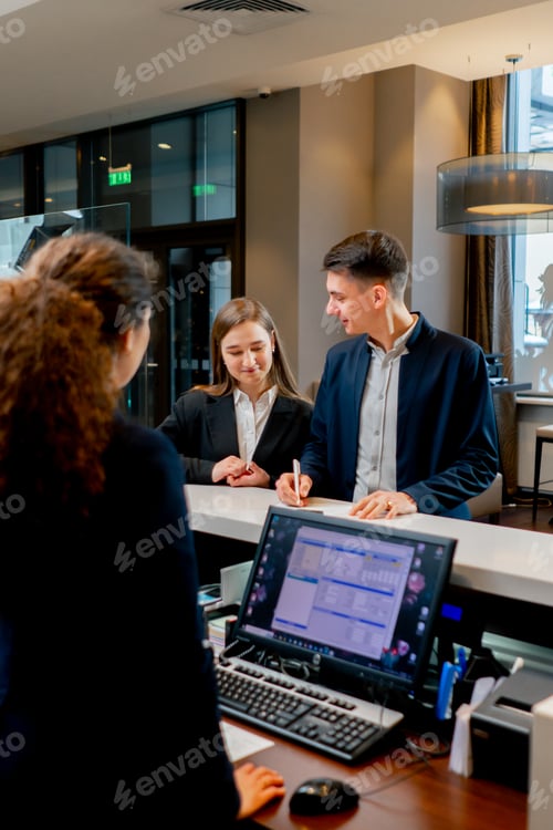 Preview: The receptionist at the counter meets guests with luggage in the hotel business travel hospitality