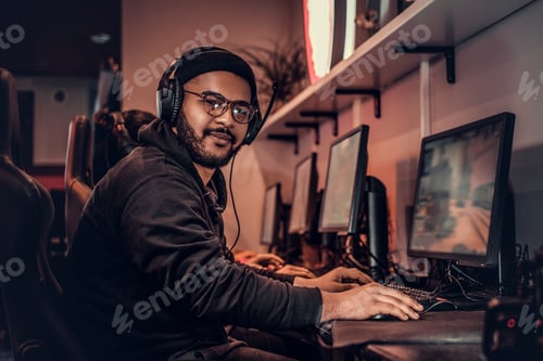 Man Wearing Headset Playing Video Game at Computer