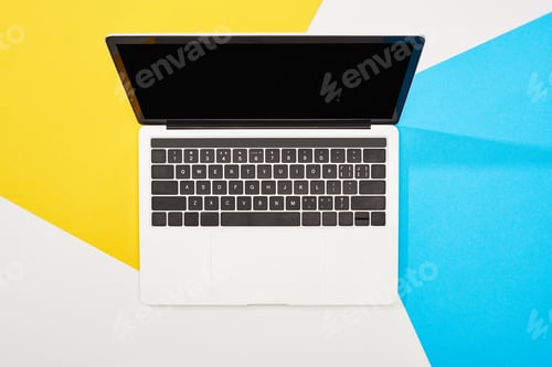 Preview: top view of laptop with blank screen on yellow, blue and white background