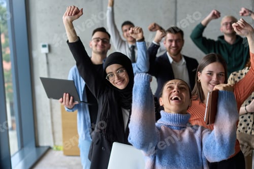 Preview: A diverse team of business professionals ecstatically celebrating their success in a modern office