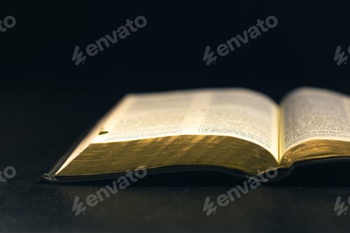 Preview: Open Bible on a black background. Religion concept.