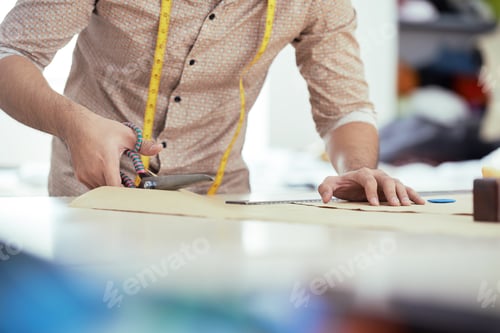 Preview: Man cuts textile with scissors