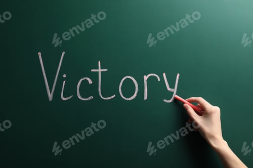 Preview: Young woman writing word Victory on chalkboard