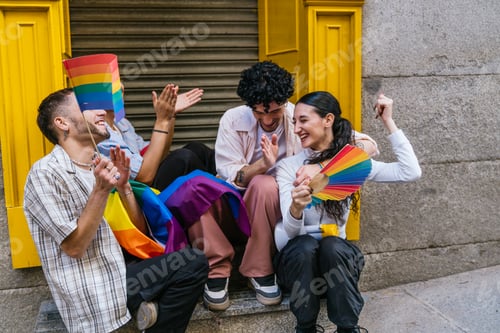 Preview: Friends celebrating pride event holding rainbow flags