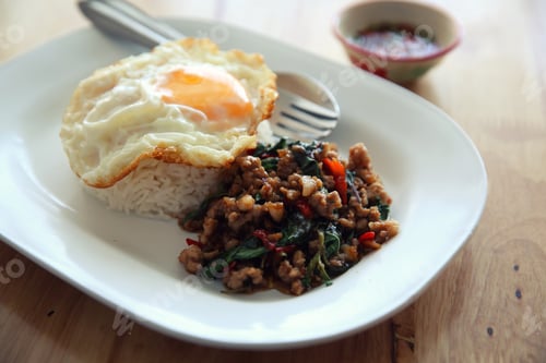Preview: Stir Fried Pork And Basil With Rice And Egg On Wood Background Thai Food