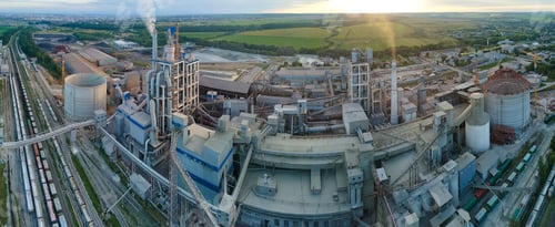 Preview: Aerial view of cement factory with high concrete plant structure and tower crane at industrial