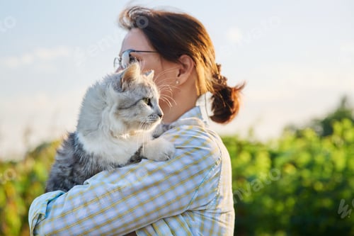 Preview: Outdoor portrait of middle aged woman with cat in her arms