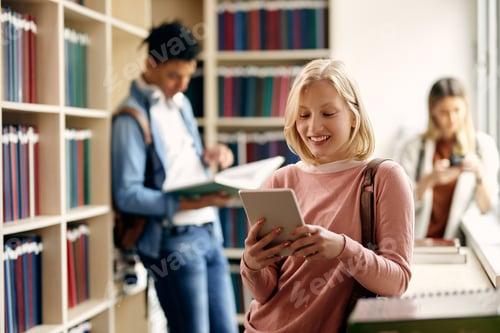 Preview: Happy female student surfing the net on touchpad at university library.