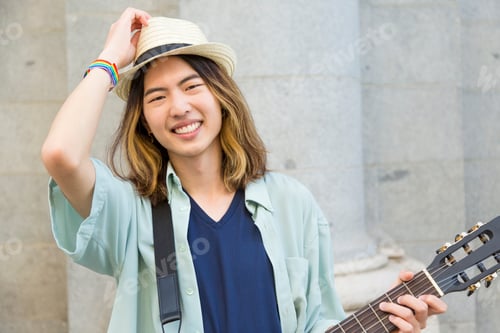 Preview: Happy young musician with hat in the street