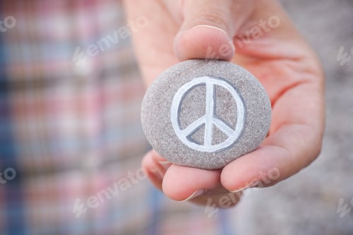 Preview: Person holds stone with peace symbol