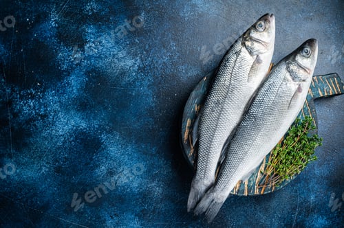 Preview: Uncooked Raw Sea Bass fish, Seabass with thyme. Blue background. Top view. Copy space