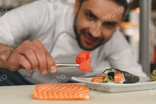 Preview: Close up of sushi master prepares sushi for serving in modern commercial kitchen