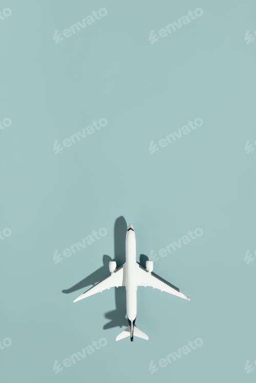 Preview: Miniature airplane on blue background with copy space