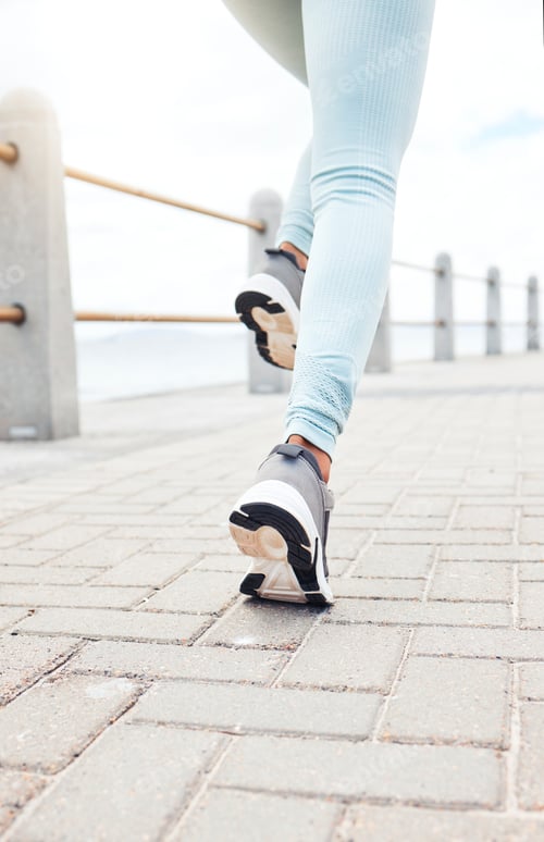 Preview: Zoom of runner, sport woman for fitness legs running, training or exercise workout by the sea, beac