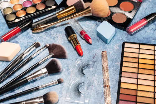 Preview: set of decorative cosmetics, makeup brushes false eyelashes on a blue background. the view from top