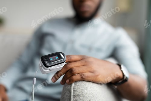 Preview: African Guy With Pulse Oximeter Monitoring Oxygen Rate At Home