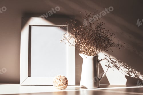 Preview: Blank picture frame and Gypsophila flowers in light with shadows, mock up. Still life