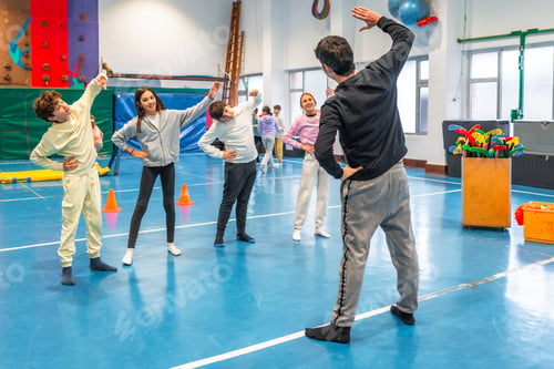 Preview: Group of students stretching with teacher in school gym