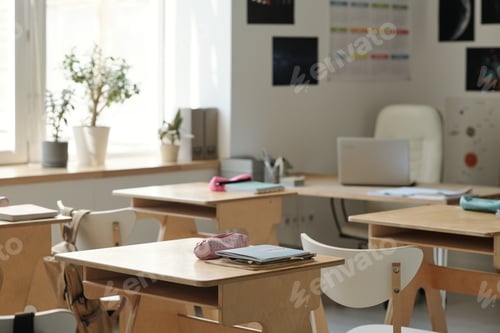 Preview: Part of spacious classroom with group of desks and workplace of teacher