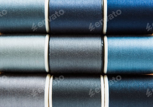 Preview: Shades of gray and blue sewing threads background closeup