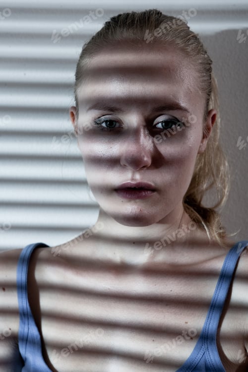 Preview: Portrait of a unhappy and depressed young woman in depressive stripe environment desaturated image