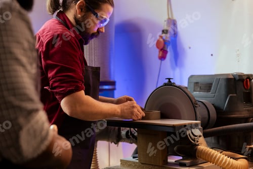 Preview: Carpenter working on disc sander wearing protection glasses