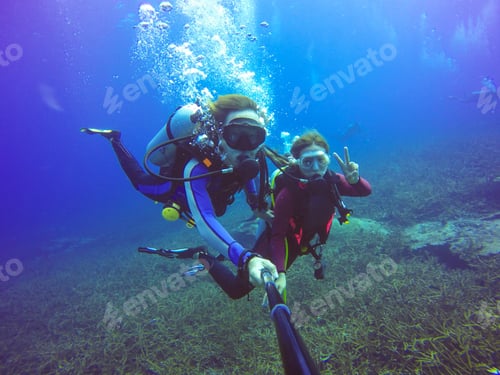 Preview: Underwater scuba diving selfie shot with selfie stick. Deep blue sea. Wide angle shot.