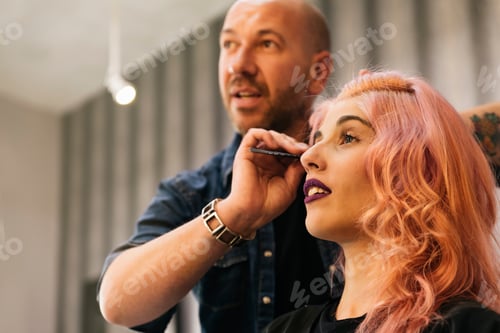 Preview: Beautiful woman getting haircut by hairdresser.