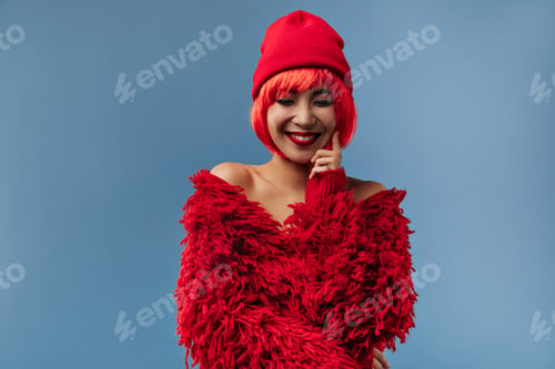Preview: Charming stylish woman with red short hair and modern makeup in fluffy bright sweater smiling and p