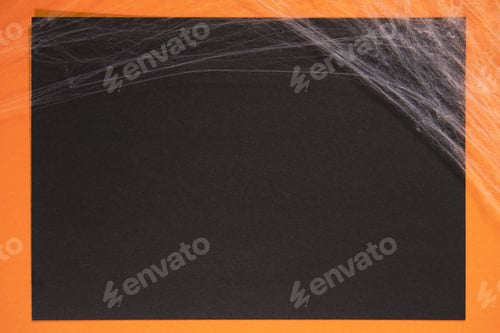 Preview: Orange and black paper background with cobwebs for Halloween