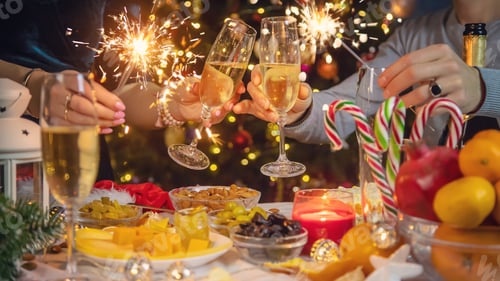 Preview: Champagne in hand against the background of the Christmas tree. People. Selective focus.