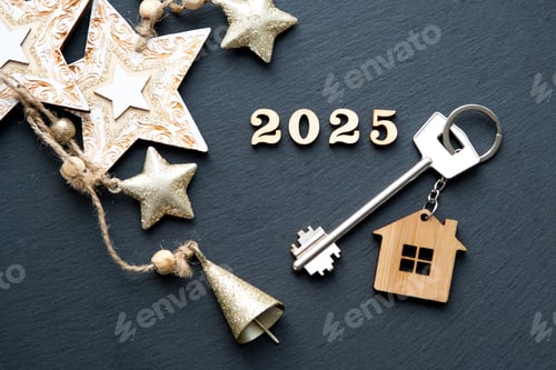 Preview: House key with keychain cottage on festive black background with stars, lights of garlands. New Year