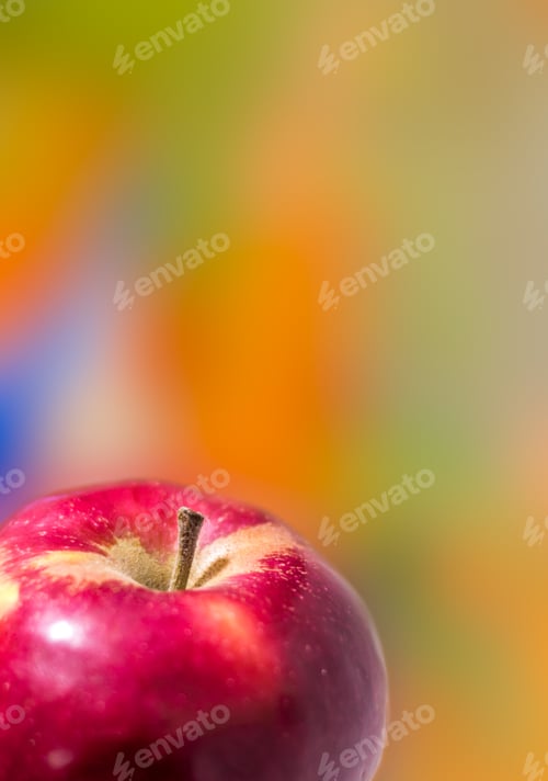Preview: Close up of a Macintosh apple against blurry colored background