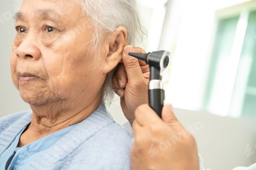 Preview: Audiologist or ENT doctor use otoscope checking ear of asian senior woman