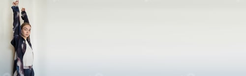 Preview: sensual woman in trendy oversize shirt standing with raised hands on white background, banner