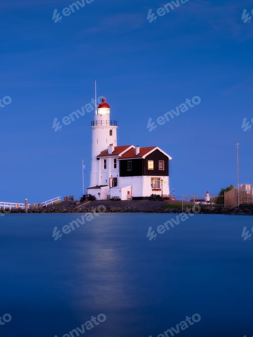 Preview: A lighthouse on the beach during blue hour. A landmark in maritime navigation. Long exposure.
